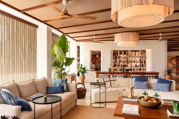 Wohnzimmer im Zel Mallorca Hotel mit Sofas, Tischen, Pflanzen und Deckenventilatoren.