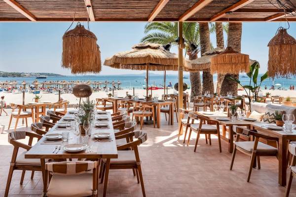 Außenbereich des Zel Mallorca Hotels mit Tisch und Stühlen, Blick auf den Strand