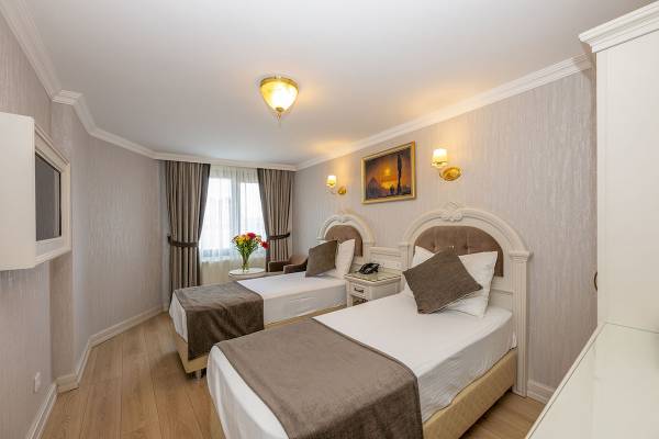 Doppelzimmer im Arden City Hotel mit zwei Betten, Tisch, Lampen und einem Bild an der Wand.
