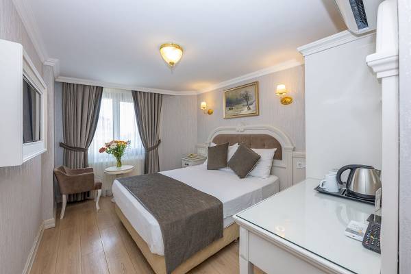 Schlafzimmer im Arden City Hotel mit Bett, Tisch, Stuhl und Fernseher.