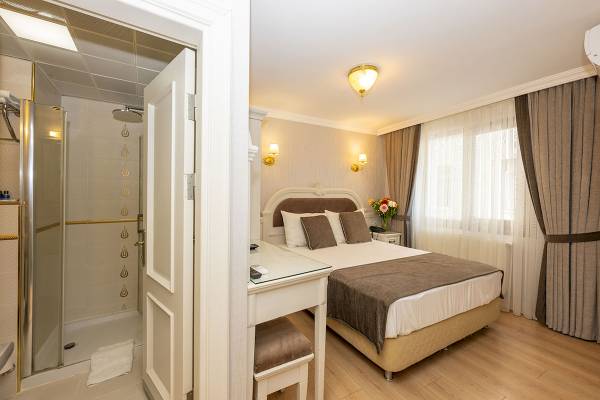 Hotelzimmer von Arden City mit Doppelbett, Nachttisch und offener Dusche