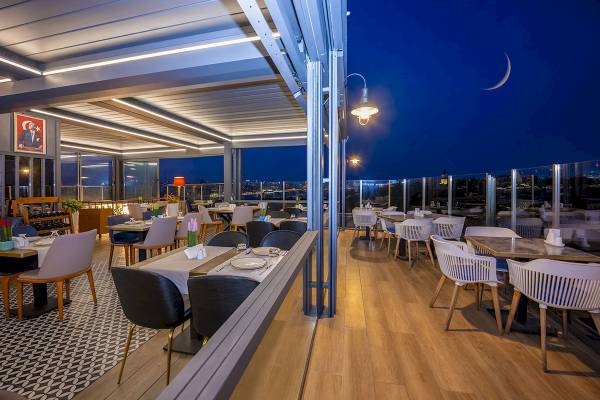 Abendansicht der Dachterrasse des Arden City Hotels mit Blick auf die Stadt