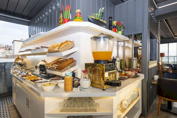 Frühstücksbuffet im Arden City Hotel mit Brot, Cerealien, Früchten und Getränken.