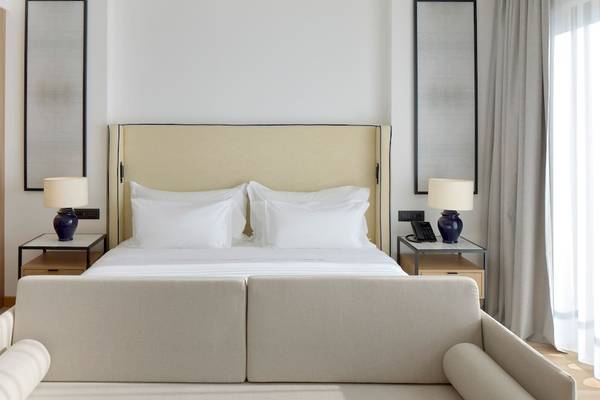 Schlafzimmer des Melia Durres Albania Hotels mit Bett, Nachttischen und Lampen
