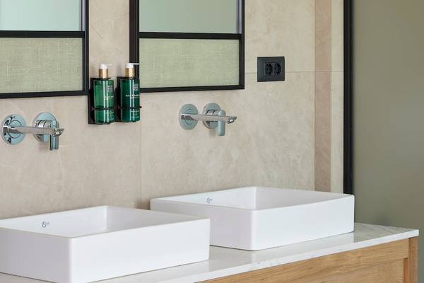 Ein Badezimmer mit zwei weißen Waschbecken und Marmorboden im Melia Durres Hotel in Albanien.