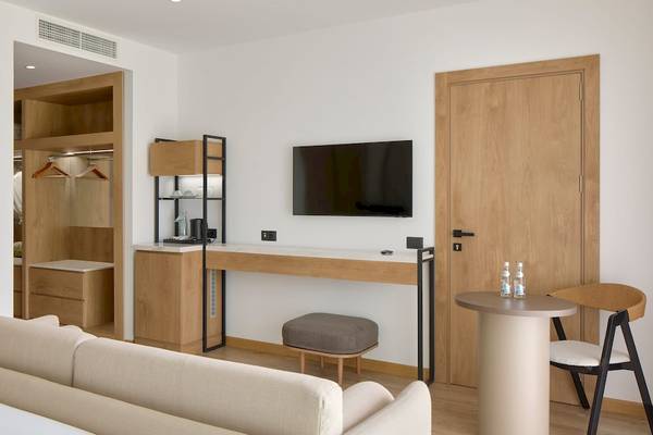 Innenansicht eines Hotelzimmers im Melia Durres Albania mit einem Sofa, Schreibtisch und Fernseher.