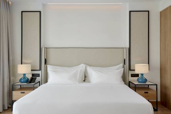 Hotelzimmer mit einem Bett und zwei Lampen auf Nachttischen neben dem Bett.