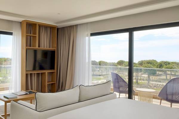 Innenansicht einer Suite im Melia Durres Albania Hotel mit Blick auf eine Terrasse und Garten.