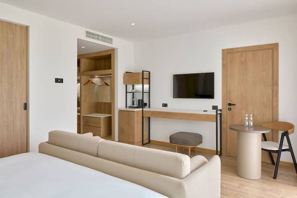 Hotelzimmer des Melia Durres Albania mit Sofa, Schreibtisch und Fernseher.