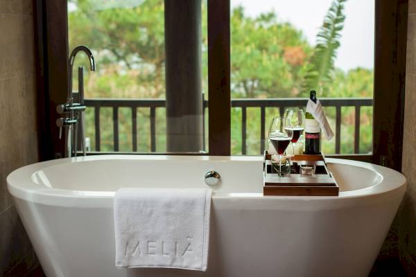 Badewanne im Melia Durres Hotel mit Aussicht auf die Terrasse und Weinglas