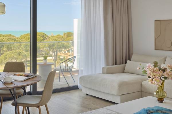 Wohnzimmer des Melia Durres Albania Hotels mit Blick auf das Meer und grünen Bäumen.