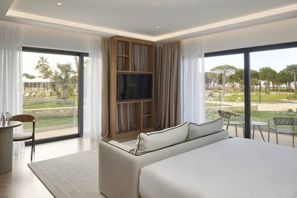 Innenansicht eines Hotelzimmers des Melia Durres Albania mit Schlafsofa, Fernseher und großer Fensterfront.