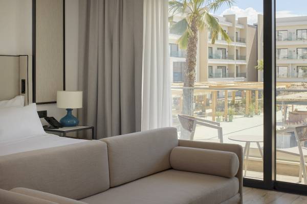 Hotelzimmer im Melia Durres Hotel in Albanien mit Blick auf eine Terrasse und Gebäude.