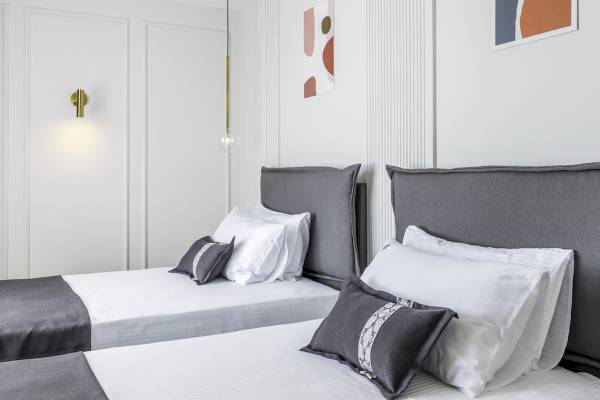 Doppelbett-Zimmer im Mövenpick Hotel Lalez Durres mit modernen Möbeln und weißen Wänden.