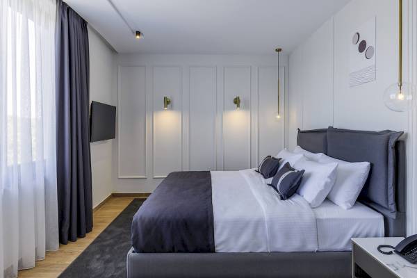 Schlafzimmer im Mövenpick Hotel Lalez Durres mit Bett, Kissen und Fernseher