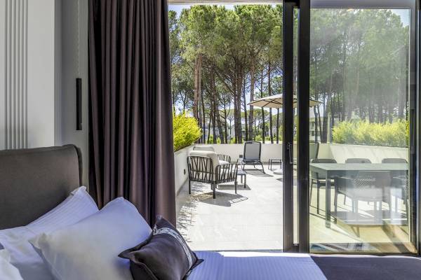 Zimmer im Mövenpick Hotel Lalez Durres mit Blick auf eine Terrasse und Außenmöbel.