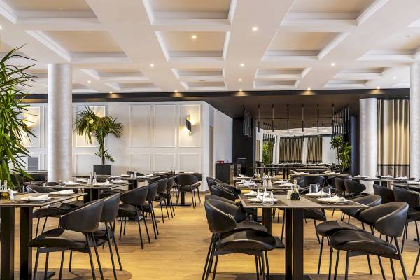 Innenbereich des Mövenpick Hotel Lalez Durres Restaurant mit gedeckten Tischen und Stühlen.