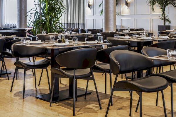 Innenbereich des Restaurants im Mövenpick Hotel Lalez Durres mit gepflegten Tischen und modernen Stühlen.