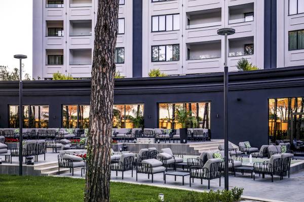 Außenbereich des Mövenpick Hotel Lalez Durres mit modernen Möbeln und Bäumen