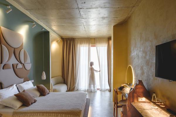 Schlafzimmer im Epidamn White Sensation Hotel mit Bett, Möbeln und Fernseher.