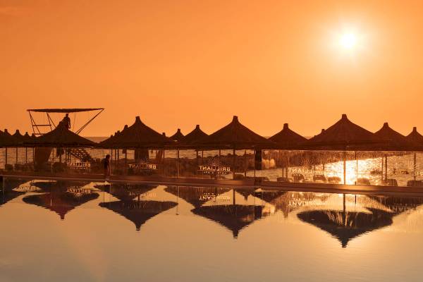 Der Pool des Brilliant Hotel & Spa mit Sonnenuntergang und Sonnenreflexionen.