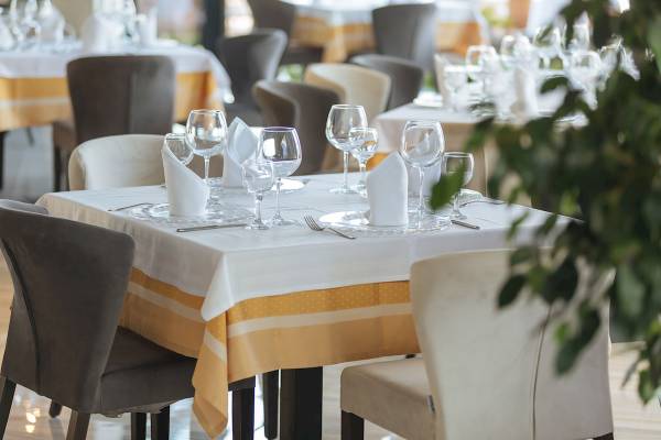 Ein Tisch im Brilliant Hotel & Spa mit gelben Tischdecken und weißen Tischwäschen.