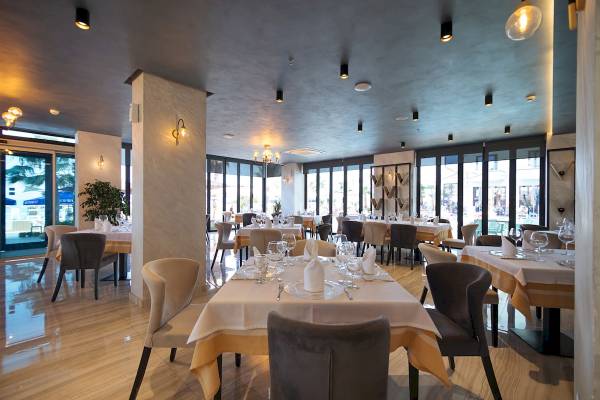 Innenansicht des Restaurants im Brilliant Hotel & Spa mit gedeckten Tischen und Stühlen.