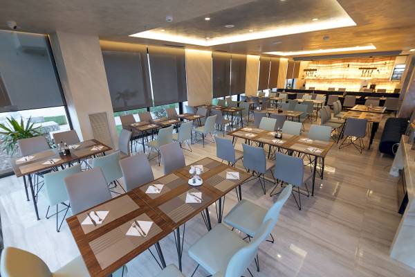 Innenbereich des Restaurants im Brilliant Hotel & Spa mit mehreren Tischen und Stühlen.