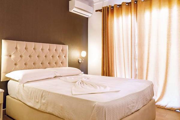 Schlafzimmer im Fafa Premium Resort mit einem Bett, zwei Kissen, Nachttisch und Wandlampen.