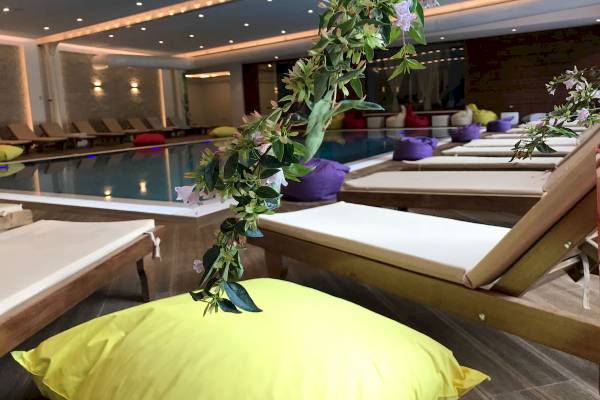 Pool-Loungebereich im Sandy Beach Resort mit Liegen und bunten Kissen.