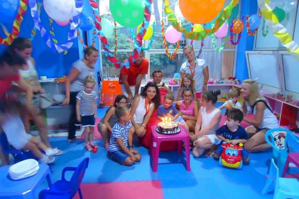 Kindergeburtstag im Sandy Beach Resort mit vielen Kindern, Erwachsenen und einer Geburtstagstorte.