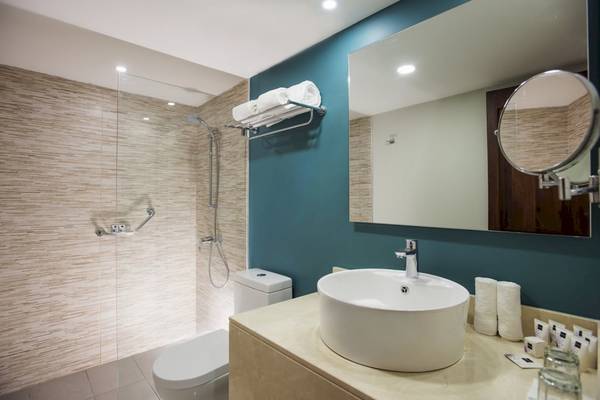 Badezimmer im Emotions By Hodelpa Puerto Plata Hotel mit Dusche, Toilette, Spiegel und Waschbecken.