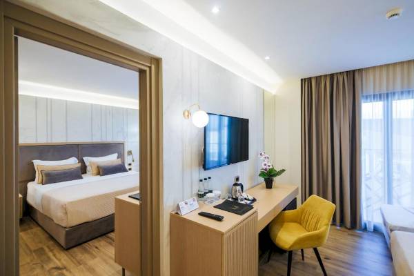 Interieur eines Hotelzimmers mit Bett, Schreibtisch und Fernseher