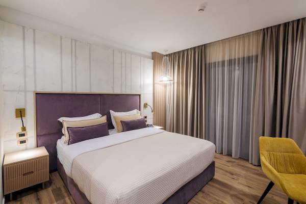 Hotelzimmer mit einem Bett, Kissen und Lampen auf Nachttischen