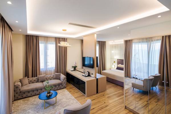 Innenansicht einer Suite im Gloria Palace Hotel mit Wohnzimmer, Schlafbereich und modernen Möbeln.