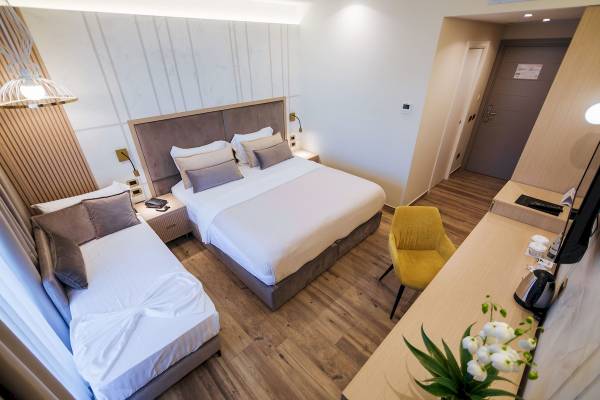 Innenansicht eines Hotelzimmers im Gloria Palace Hotel mit zwei Betten, einem Schreibtisch und einem Stuhl.