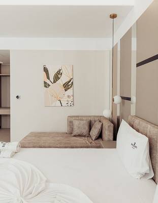 Schlafzimmer im Delight Hotel mit einem Doppelbett, einem Sofa und einer Wanddekoration.