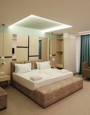 Schlafzimmer im Delight Hotel mit Bett, Nachttischen und modernem Design.