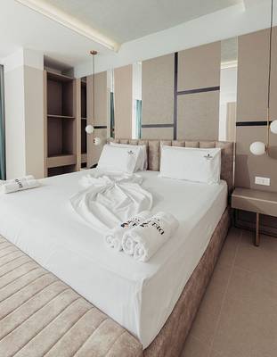 Hotelzimmer im Delight Hotel mit einem großen Bett und weißen Handtüchern.