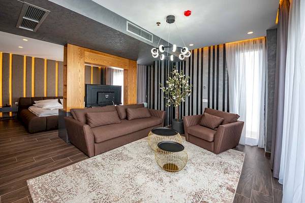 Wohnzimmer des Henry Resort & Spa mit einem großen Sofa, zwei Sesseln, einem Teppich und einer Lampe.
