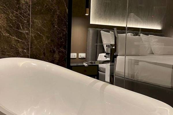 Schlafzimmer im Klajdi Resort & SPA mit Badewanne, Bett und Marmorwand