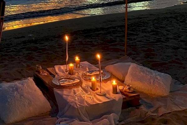 Dinner-Setup am Strand des Klajdi Resort & SPA mit Kerzen und Tischdecken.