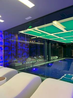 Innenpool-Bereich des Klajdi Resort & SPA mit blauen und grünen Beleuchtungselementen.