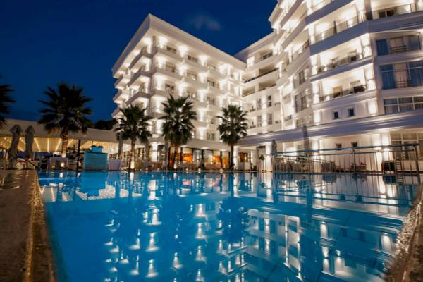 Nachtansicht des Klajdi Resort & SPA mit beleuchtetem Außenpool und Hotelgebäude.