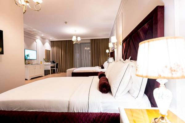Schlafzimmer im Diamma Resort mit zwei Betten, Fernseher, Tisch und Lampen.