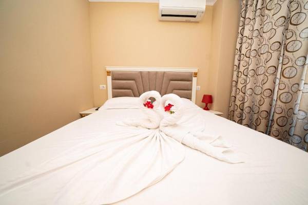 Ein Hotelzimmer von Vila Mare mit einem Bett und einem Betttuch, das in Form eines Schwans gebunden ist.
