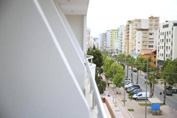 Blick von Hotel Vila Mare auf eine Straße mit Parkplatz und Bäumen.