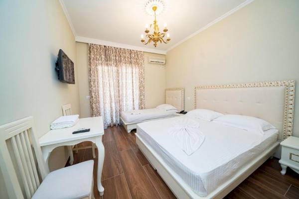 Innenansicht eines Doppelzimmers im Vila Mare Hotel mit zwei Betten, Tisch, Stühlen und Fernseher.
