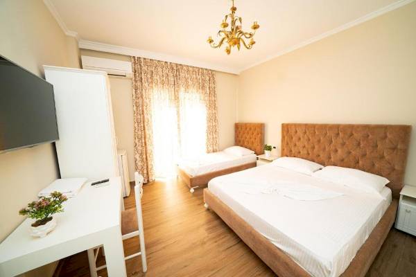Innenansicht eines Zimmers im Vila Mare Hotel mit zwei Betten, Schreibtisch, Fernseher und Dekor.