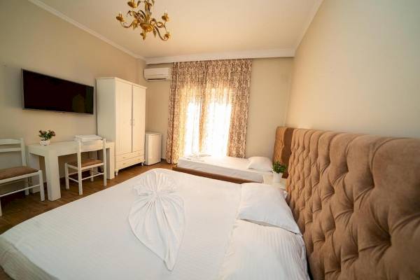 Ein geräumiges Hotelzimmer mit zwei Betten, Schreibtisch, Fernseher und einem Wohnzimmerbereich.